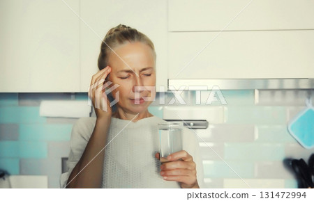 Sick woman looks at glass of water, female patient does not want to take medicine 131472994