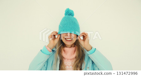 Portrait of happy funny smiling young woman in blue winter hat having fun on white background Portrait of happy funny smiling young woman in blue winter hat having fun on white background 131472996