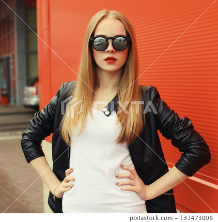 Stylish young woman standing in black leather jacket, sunglasses, modern blonde girl posing in city Stylish young woman standing in black leather jacket, sunglasses, modern blonde girl posing in city 131473008