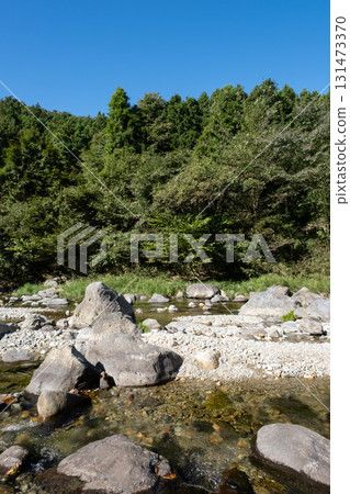 A river flowing through the blue sky and green mountains 131473370