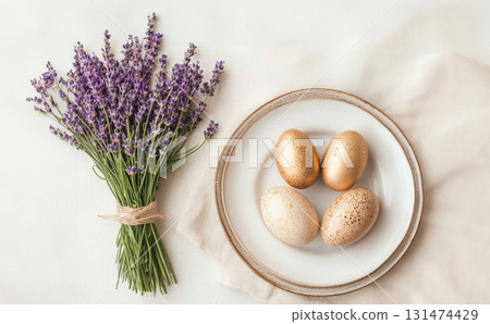 Luxury Happy Easter. Elegant top view, layout, minimalist style, Easter decorated table with golden eggs and lavender bouquet arranged on napkin with matching cutlery and glassware. 131474429