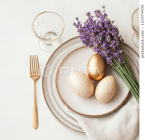 Luxury Happy Easter. Elegant top view, layout, minimalist style, Easter decorated table with golden eggs and lavender bouquet arranged on napkin with matching cutlery and glassware. 131474430