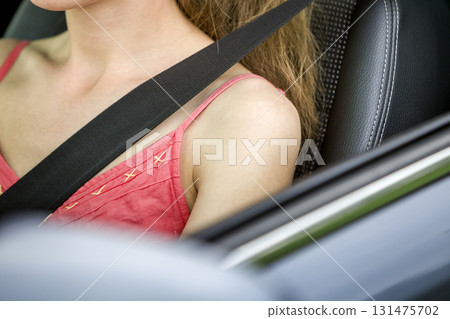 Young woman inside vehicle wearing protective seat belt. Safety and precaution concept. Young woman inside vehicle wearing protective seat belt. Safety and precaution concept. 131475702