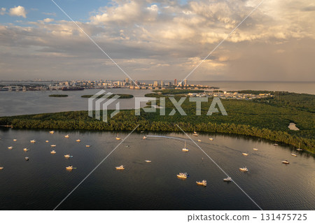 Yachting in Miami, Florida. Recreational yachts and fishing boats anchored in Biscayne Bay harbor. Evening over urban skyline with high-rise buildings in downtown Yachting in Miami, Florida. Recreational yachts and fishing boats anchored in Biscayne Bay harbor. Evening over urban skyline with high-rise buildings in downtown 131475725