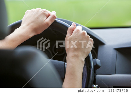 Woman hands on steering wheel driving a car. Woman hands on steering wheel driving a car. 131475736