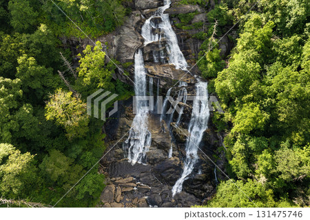 Whitewater Falls with falling down clear water from rocky boulders between green lush woods in Nantahala National Forest, North Carolina, USA Whitewater Falls with falling down clear water from rocky boulders between green lush woods in Nantahala National Forest, North Carolina, USA 131475746
