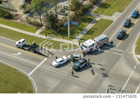 Tow truck hauling damaged car in traffic accident from crash site on American road 131475826