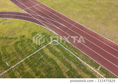 Top view of red running tracks and green grass lawn. Infrastructure for sports activities. Top view of red running tracks and green grass lawn. Infrastructure for sports activities. 131475829