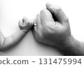 Two hands: man and child. Father and son touching fists. Dad and newborn son boys holding hands together. Little and big fists of father and son. Black and white professional photo.  131475994