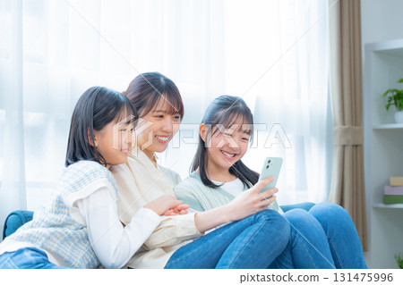 家庭：媽媽和女孩看著智慧型手機 131475996