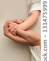 Close-up little hand of child and palm of mother and father. The newborn baby has a firm grip on the parent's finger after birth. A newborn holds on to mom's, dad's finger.  131475999