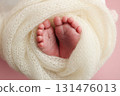 Close up of toes, heels and feet of a newborn baby.The tiny foot of a newborn. Soft feet of a newborn in a white blanket, pink background.  131476013