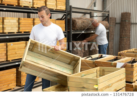 Young man choosing wooden box in store Young man choosing wooden box in store 131476728