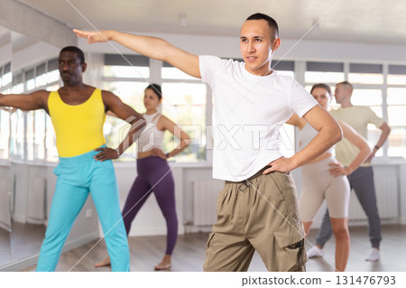Asian guy performing salsa at group Latin dance lesson 131476793