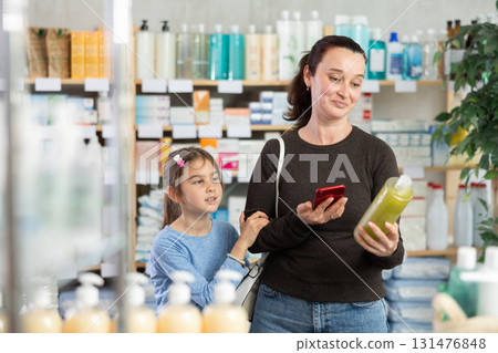Woman scanning barcode on shampoo bottle 131476848