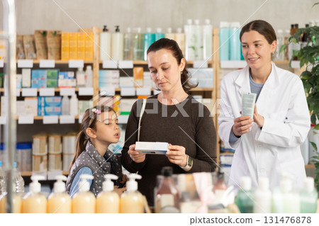 woman chooses a medical ointment in a pharmacy with a pharmacist woman chooses a medical ointment in a pharmacy with a pharmacist 131476878