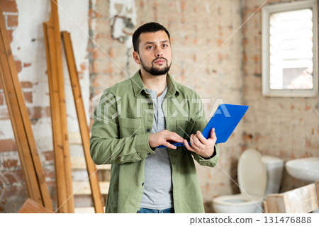 Man with laptop on indoor construction site Man with laptop on indoor construction site 131476888