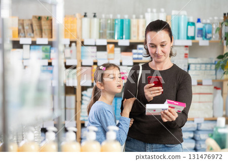 Woman with daughter scanning qr code of paracetamol Woman with daughter scanning qr code of paracetamol 131476972