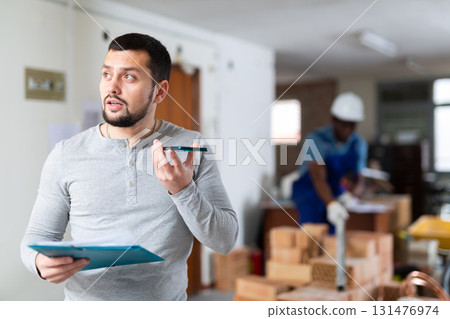 Construction manager with paper folder having telephone conversation Construction manager with paper folder having telephone conversation 131476974