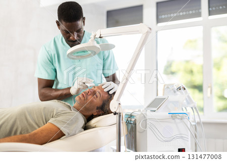 Skilled dermatologist used skin scrubber Skilled dermatologist used skin scrubber 131477008