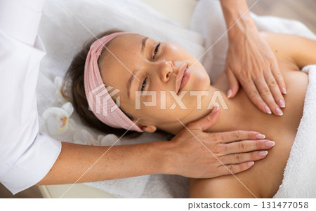 Young woman gets massage of her collarbones and neck Young woman gets massage of her collarbones and neck 131477058