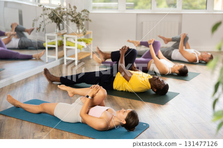 Young woman coach and students perform wind release during training in studio Young woman coach and students perform wind release during training in studio 131477126