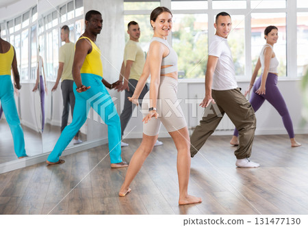 Smiling young girl enjoying vigorous dance at group class 131477130