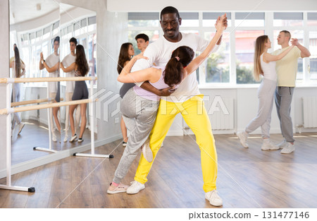Woman dances incendiary tango with African man partner during choreography lesson 131477146