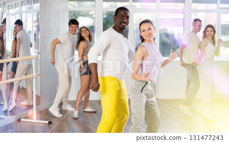 Middle-aged man and woman practicing active dance in pair in training hall Middle-aged man and woman practicing active dance in pair in training hall 131477243