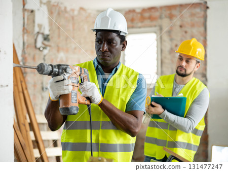 Confident builder posing on indoor construction site 131477247