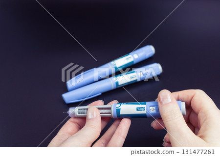 Insulin injection pen on a dark background for diabetics and weight loss. Insulin injection pen on a dark background for diabetics and weight loss. 131477261