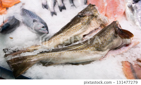 Crumbled ice, carcasses of gutted and decapitated cod fish trunk lie on its surface, close up 131477279