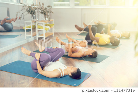 Young woman coach and students perform wind release during training in studio Young woman coach and students perform wind release during training in studio 131477319