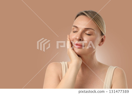 Woman applies skincare while relaxing in a quiet space 131477389