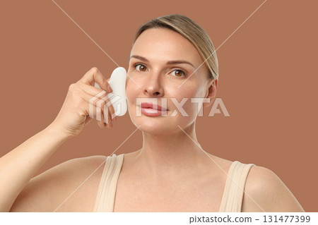 Woman enjoys a soothing facial treatment with gentle movements Woman enjoys a soothing facial treatment with gentle movements 131477399