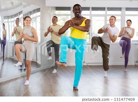 African american fitness trainer leading dynamic zumba class African american fitness trainer leading dynamic zumba class 131477409