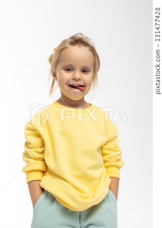 Portrait of beautiful cute little toddler girl. Child with funny face in yellow sweatshirt. Pretty smile kid in studio on white background. High quality photo Portrait of beautiful cute little toddler girl. Child with funny face in yellow sweatshirt. Pretty smile kid in studio on white background. High quality photo 131477428