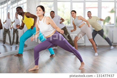 Asian girl with team of like-minded multinational people learn to elements of hip hop dance Asian girl with team of like-minded multinational people learn to elements of hip hop dance 131477437