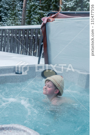 Cheerful happy family with children enjoys hot bath in jacuzzi whirlpool on cold winter day. Carefree relaxation in hot tub outdoors of nature. Meeting and chatting with relatives. Cheerful happy family with children enjoys hot bath in jacuzzi whirlpool on cold winter day. Carefree relaxation in hot tub outdoors of nature. Meeting and chatting with relatives. 131477556