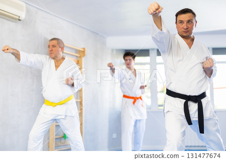 Martial arts instructor leading judo kata training for group of men 131477674