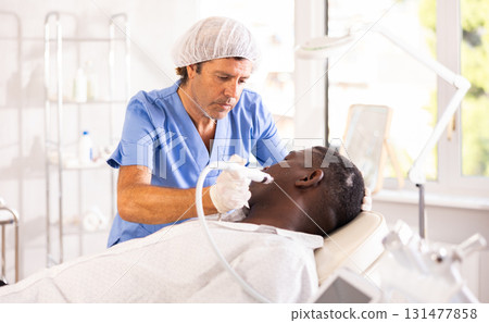Specialist administers cosmetic treatment 131477858
