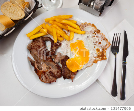Veal with eggs and potatoes on a plate 131477906