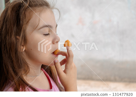 Young girl is holding yellow raspberries on her fingers and tasting. High quality photo Young girl is holding yellow raspberries on her fingers and tasting. High quality photo 131477920