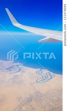 View from the window of plane on blue sky and earth with landscape of desert, sea and canals in Emirates. High quality photo 131478095