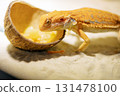 Red bearded Agama iguana eating fresh fruits and carrots in terrarium. Pogona is genus of reptiles. Cute amazing animal from Australia. Content of exotic lizard at home. High quality photo 131478100