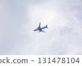 View of airplane flying in gray sky among white clouds. High quality photo 131478104