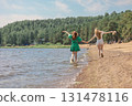 Smiling girls walking along coastline. Concept of friendship, entertainment and fun. High quality photo 131478116