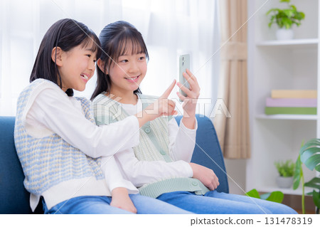 家庭：姊妹們正在看智慧型手機 131478319