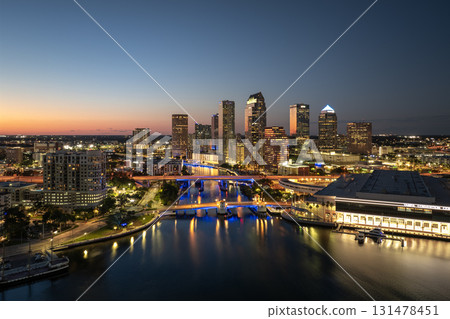 Tampa, Florida. Downtown district of American city after sunset with brightly illuminated high buildings and highway bridge traffic. USA travel destination. Tampa, Florida. Downtown district of American city after sunset with brightly illuminated high buildings and highway bridge traffic. USA travel destination. 131478451