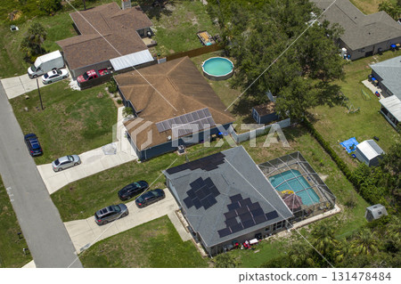 Solar roof covered with photovoltaic panels on private house for producing of clean ecological electricity in suburban rural area. Concept of investing in autonomous home for energy saving Solar roof covered with photovoltaic panels on private house for producing of clean ecological electricity in suburban rural area. Concept of investing in autonomous home for energy saving 131478484